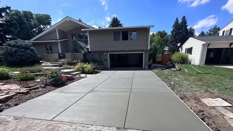 A new concrete driveway with a broom finish and cut joints.